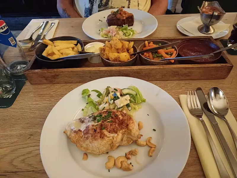 Kip met cashewnoten, biefstuk en schaaltjes friet, aardappeltjes, groente en saus