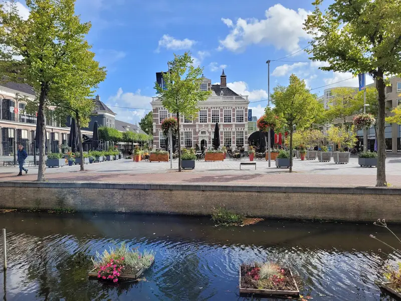 Een plein met bomen en een grachtje in het centrum van Heerenveen