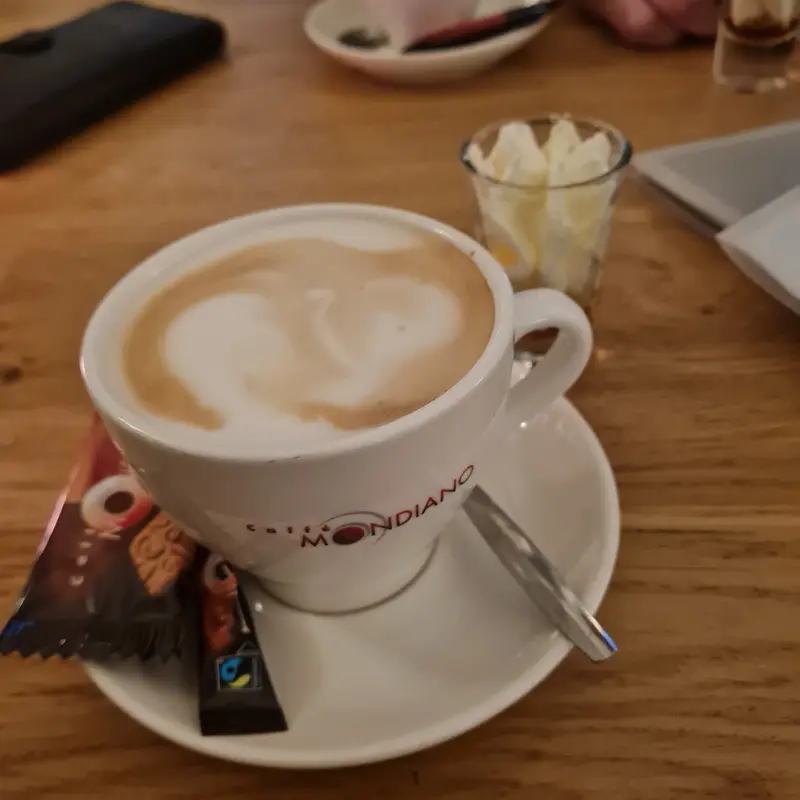Cappuccino met een chocolaatje op het schoteltje